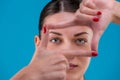 Beauty portrait of a young attractive Brunette woman with perfect skin posing and showing frame with fingers. Indoor Royalty Free Stock Photo