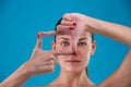 Beauty portrait of a young attractive Brunette woman with perfect skin posing and showing frame with fingers. Indoor Royalty Free Stock Photo