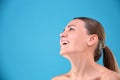 Beauty portrait young attractive half naked woman with perfect skin laughing and looking at camera isolated over blue Royalty Free Stock Photo