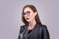 Beauty portrait of young attractive woman wearing glasses with agressive make-up dressed in laither jacket Royalty Free Stock Photo