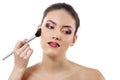beauty portrait of young beautiful woman with hand of esthetician applying rouge with brush