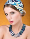 Beauty portrait of young beautiful woman with sensual look. Necklace and hair with a headscarf Royalty Free Stock Photo