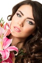 Beauty portrait of young brunette woman near pink lily Royalty Free Stock Photo