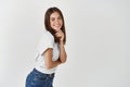 Beauty. Portrait of young brunette woman posing over white background, smiling and looking coquettish at camera Royalty Free Stock Photo