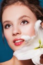 Beauty portrait of young woman with the lily flower on blue Royalty Free Stock Photo