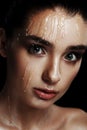 Beauty Portrait of Young Woman with Strobing Makeup Liquid on Fa