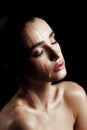 Beauty Portrait of Young Woman with Strobing Makeup Liquid on Fa