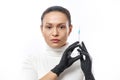 Beauty portrait of a young woman wearing black protective gloves and holding syringe near her face isolated on a white background Royalty Free Stock Photo