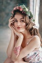 Beauty portrait of young woman with wreath of flowers in hair