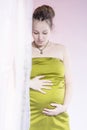 Beauty pregnant woman behind curtain