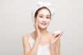 Beauty procedures skincare concept. Young woman applying facial  mud clay mask to her face in bathroom Royalty Free Stock Photo