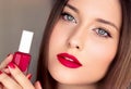 Beauty product, makeup and cosmetics, face portrait of beautiful woman with nail polish, manicure and matching red Royalty Free Stock Photo