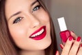 Beauty product, makeup and cosmetics, face portrait of beautiful woman with nail polish, manicure and matching red Royalty Free Stock Photo