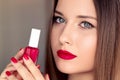 Beauty product, makeup and cosmetics, face portrait of beautiful woman with nail polish, manicure and matching red Royalty Free Stock Photo
