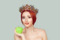 Beauty queen craving for vitamins sugars. Pretty woman with crystal crown on head holding green apple in hand biting lips isolated Royalty Free Stock Photo