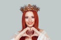 Beauty queen expressing love. Pretty romantic young girl making a heart gesture with her fingers, showing her love care for others Royalty Free Stock Photo