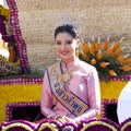 Beauty queen in traditional dress sit on a float.