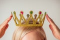 Beauty queen woman blonde put on placing tiara crown on head high self esteem selfishness studio white background