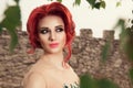 Beauty red head curly hair young woman portrait outside green park background looking away to the side