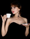 Beauty retro female model with professional makeup, drinking coffee or tea. fashion vintage woman on a dark background Royalty Free Stock Photo