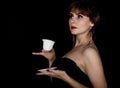 Beauty retro female model with professional makeup, drinking coffee or tea. fashion vintage woman on a dark background Royalty Free Stock Photo