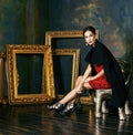 Beauty rich brunette woman in luxury interior near empty frames, vintage elegance