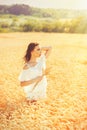 Beauty romantic girl enjoying nature in outdoors. Happy young woman in white shorts on the field of golden ripe wheat Royalty Free Stock Photo