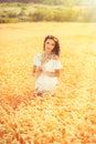 Beauty romantic girl enjoying nature in outdoors. Happy young woman in white shorts on the field of golden ripe wheat Royalty Free Stock Photo