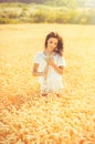 Beauty romantic girl enjoying nature in outdoors. Happy young woman in white shorts holding the ears of golden ripe wheat Royalty Free Stock Photo