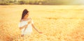 Beauty romantic girl enjoying nature in outdoors. Happy young woman in white shorts holding the ears of golden ripe wheat Royalty Free Stock Photo