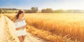 Beauty romantic girl enjoying nature in outdoors. Happy young woman in white shorts holding the ears of golden wheat Royalty Free Stock Photo