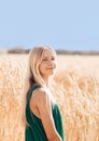 Beauty Romantic girl outdoors. Beautiful teen model girl in green dress on the field in sunlight. Blowing long blond hair.  Glow Royalty Free Stock Photo