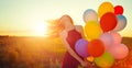 Beauty romantic girl on summer field with colorful air balloons