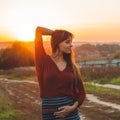 Beauty Romantic is pregnant Girl Outdoors enjoying nature holding her belly Beautiful autumn model in nature in the rays of sunset Royalty Free Stock Photo