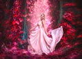 Beauty romantic young woman in long chiffon dress with gown posing in fantasy misty forest. Beautiful happy bride model girl