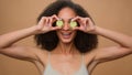 Beauty routine happy young girl beautiful attractive African American woman with curly hair holding fresh cucumber Royalty Free Stock Photo