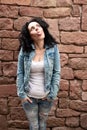 naughty mature woman with curly dark hair and white shirt and jeans jacket sticks out her tongue Royalty Free Stock Photo