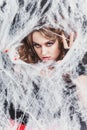 Beauty Witch girl caught in a spider web. Fashion Art design. Beautiful Gothic model girl with Halloween make up Royalty Free Stock Photo