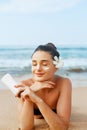 Beauty Sexy Young Woman in Bikini Holding Bottles of Sunscreen in Her Hands. Skin care. A Beautiful Female Applying Sun Cream. Royalty Free Stock Photo