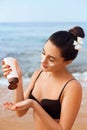 Beauty Sexy Young Woman in Bikini Holding Bottles of Sunscreen in Her Hands. Skincare. A Beautiful Female Applying Sun Cream. Usin Royalty Free Stock Photo