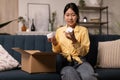 Happy Asian woman unpacking parcel after online shopping Royalty Free Stock Photo