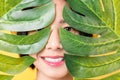 Beauty shot of Asian woman holding green leaves to touch the face on the orange background. Royalty Free Stock Photo