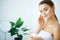 Beauty Skin Care. Beautiful Woman Applying Cosmetic Face Cream Royalty Free Stock Photo