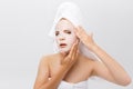 Beauty Skin Care Concept - Beautiful Caucasian Woman applying paper sheet mask on her face white background. Royalty Free Stock Photo