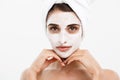 Beauty skin care concept - beautiful caucasian woman face portrait applying cream mask on her facial skin white Royalty Free Stock Photo