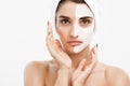 Beauty Skin Care Concept - Beautiful Caucasian Woman Face Portrait applying cream mask on her facial skin white Royalty Free Stock Photo