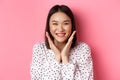 Beauty and skin care concept. Close-up of cute asian woman showing clean perfect face and smiling, looking happy at Royalty Free Stock Photo