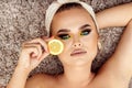 Beauty and skin care concept with gorgeous woman covering one eye with organic lemon