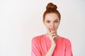 Beauty and skincare. Close-up of cute teen girl with freckles and red hair combedin messy bun, smiling thoughtful at Royalty Free Stock Photo