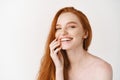 Beauty and skincare. Close-up of happy redhead woman with pale perfect skin, laughing and showing white teeth, standing Royalty Free Stock Photo